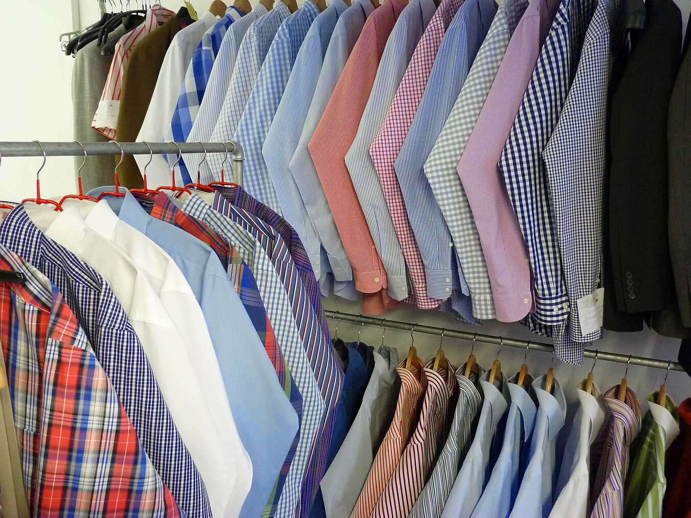 Reihe handgebügelter Hemden auf Kleiderbügeln